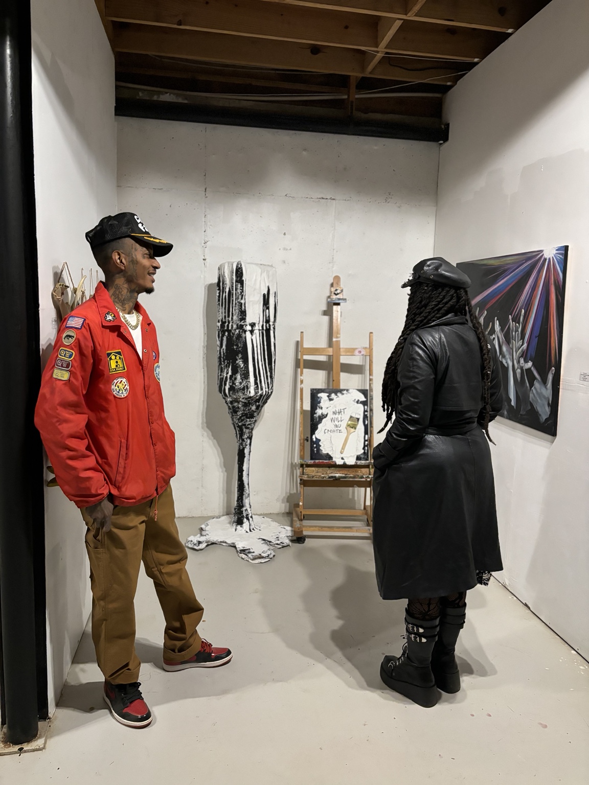 Two people talking among artwork in the gallery